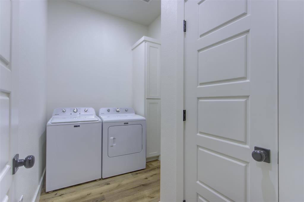 550 Capstone Rdg Road Santo, TX 76472 - Photo 12 of 40 Washroom with independent washer and dryer, light wood-type flooring, and cabinet space