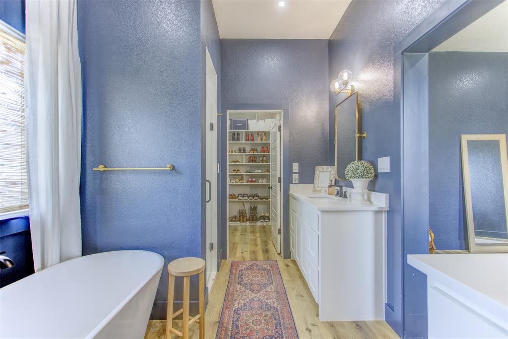 550 Capstone Rdg Road Santo, TX 76472 - Photo 18 of 40 Bathroom with a textured wall, wood finished floors, vanity, a freestanding bath, and a walk in closet