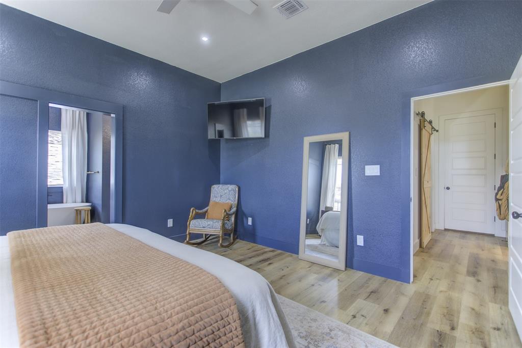 550 Capstone Rdg Road Santo, TX 76472 - Photo 19 of 40 Bedroom with a textured wall, light wood-style flooring, a ceiling fan, and high vaulted ceiling