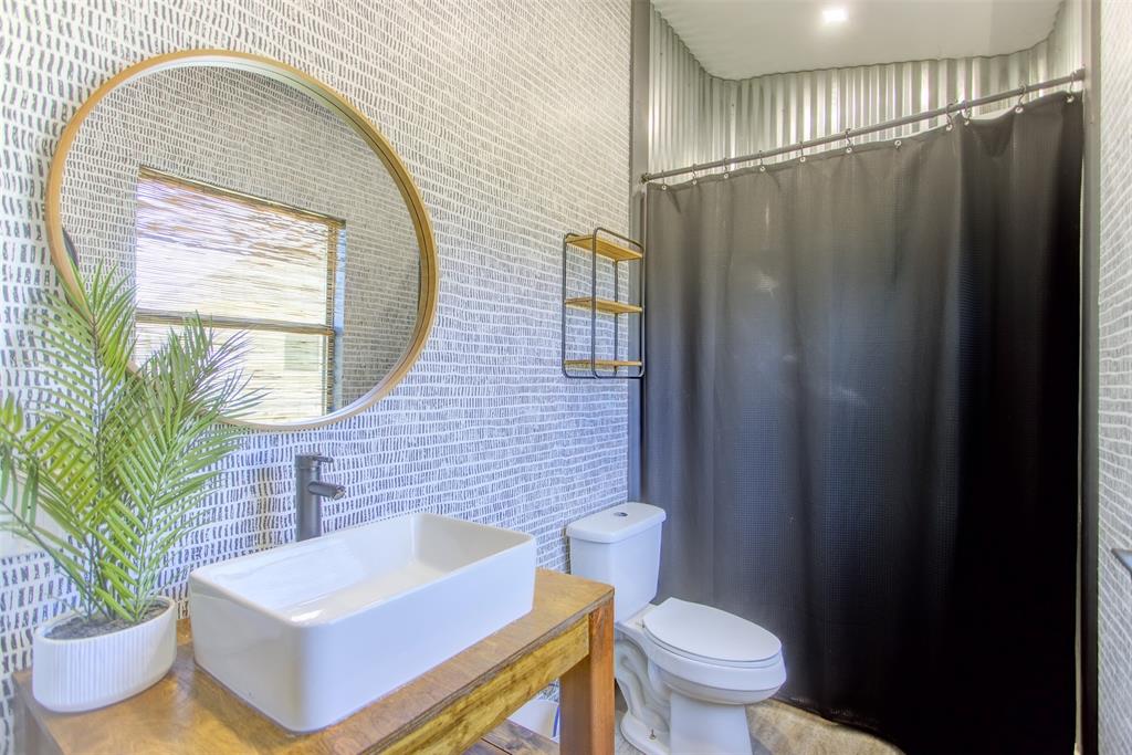 550 Capstone Rdg Road Santo, TX 76472 - Photo 35 of 40 Full bath featuring a sink, toilet, tile walls, and a shower with shower curtain