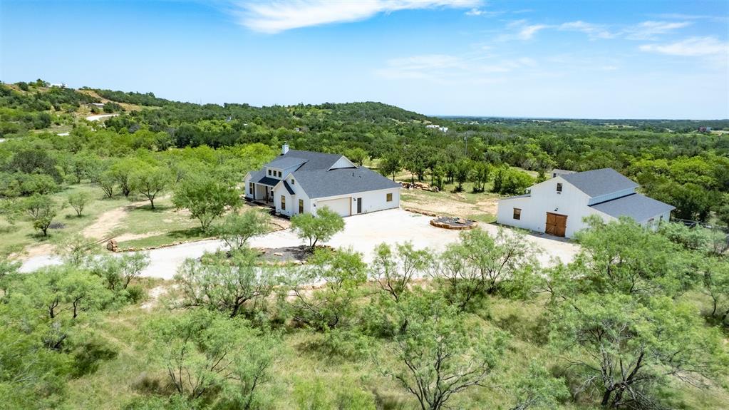 550 Capstone Rdg Road Santo, TX 76472 - Photo 4 of 40 Aerial view of property and surrounding area with a heavily wooded area