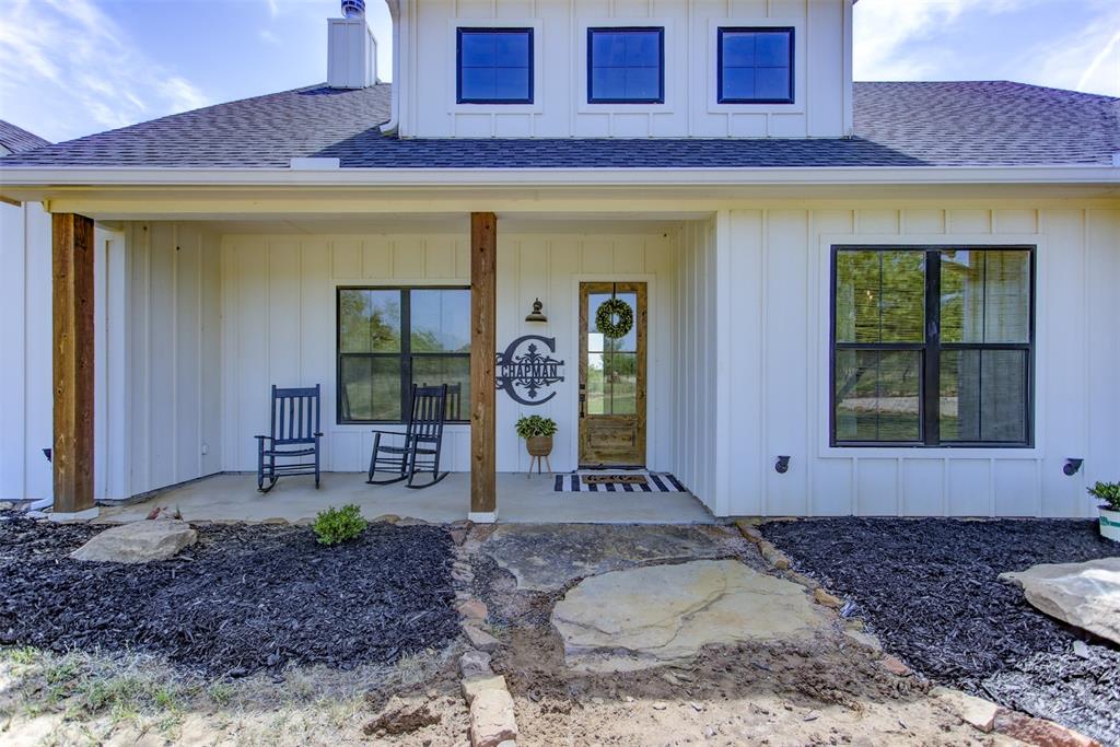 550 Capstone Rdg Road Santo, TX 76472 - Photo 8 of 40 Entrance to property featuring roof with shingles, a porch, a chimney, and board and batten siding