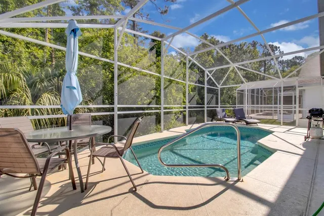 a view of a swimming pool with a patio and a yard
