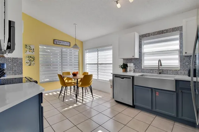 a kitchen with a table chairs sink and cabinets