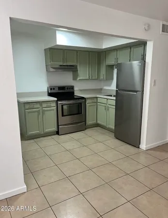a kitchen with a refrigerator and a stove top oven