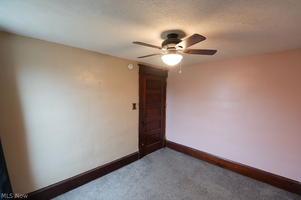 1195 South Johnson Road Sebring, OH 44672 - Photo 19 of 34 Unfurnished room featuring a textured ceiling, a ceiling fan, and carpet floors