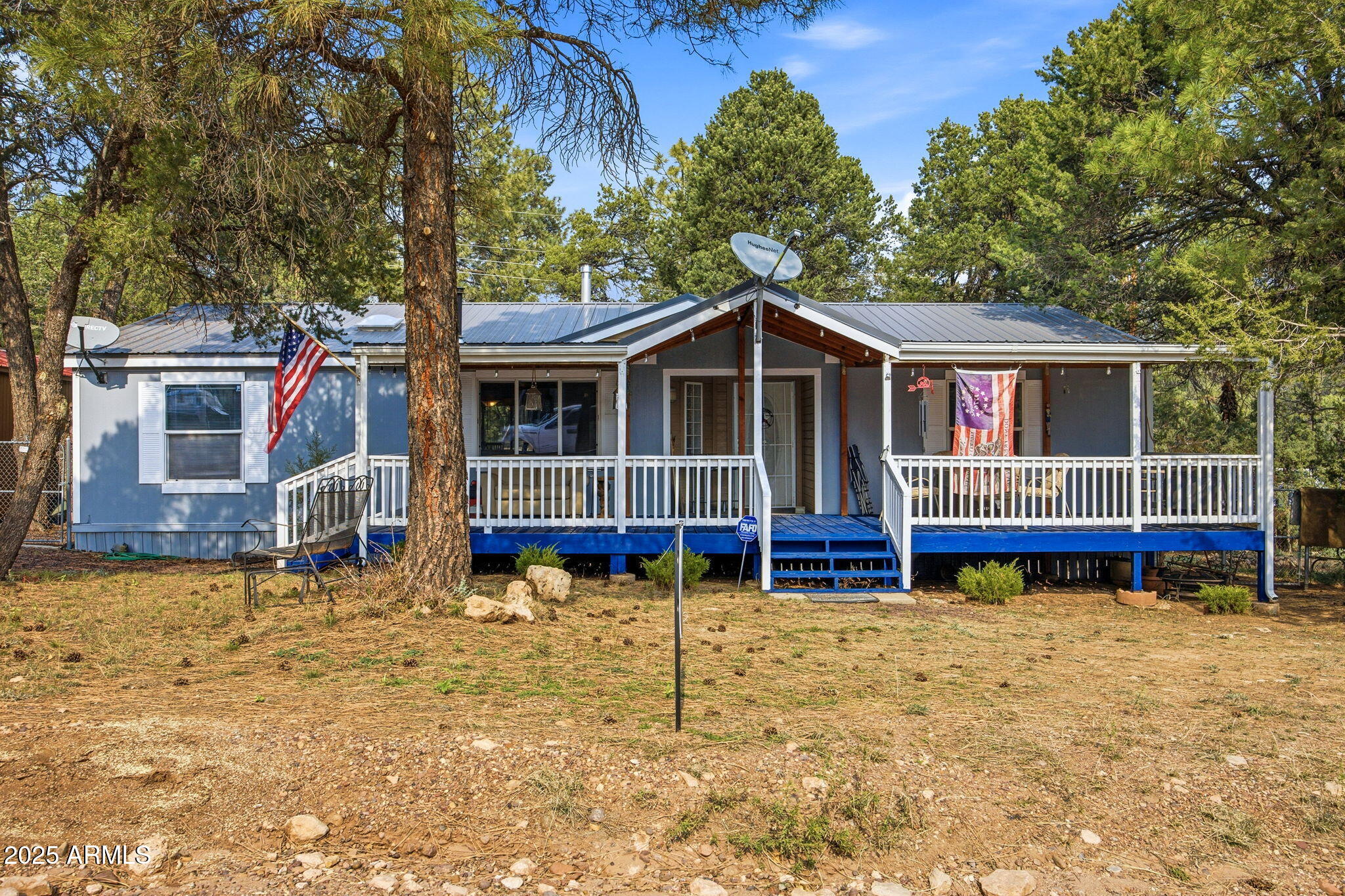 2190 Wildlife Trail Overgaard, AZ 85933 - Photo 3 of 34 a front view of a house with large trees and a small yard