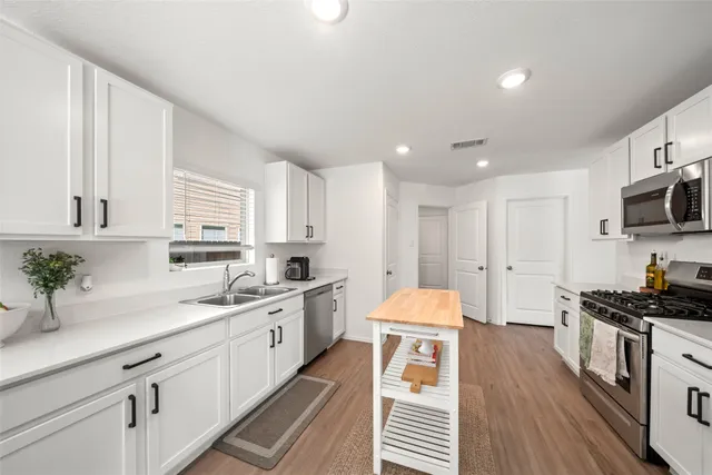 a kitchen with a sink stove and cabinets