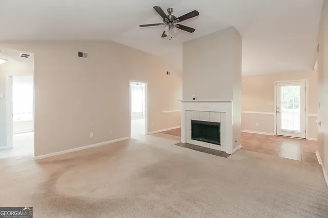 an empty room with a fireplace and windows