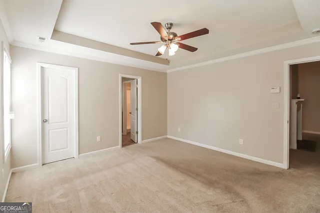 an empty room with closet and fan