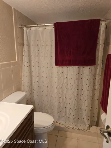 a bathroom with a toilet and a shower curtain