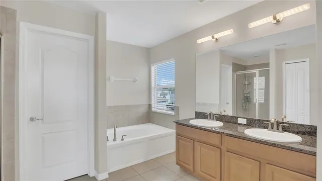 a bathroom with a tub a sink and mirror