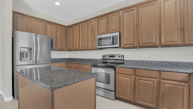 a kitchen with stainless steel appliances granite countertop a refrigerator sink and cabinets