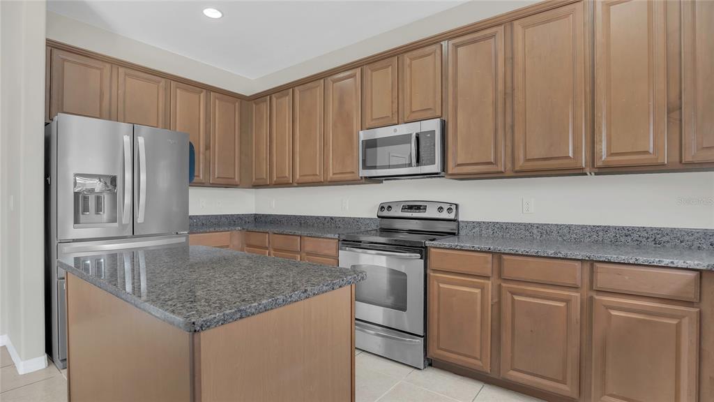 545 Fairhaven Drive Davenport, FL 33837 - Photo 3 of 23 a kitchen with stainless steel appliances granite countertop a refrigerator sink and cabinets