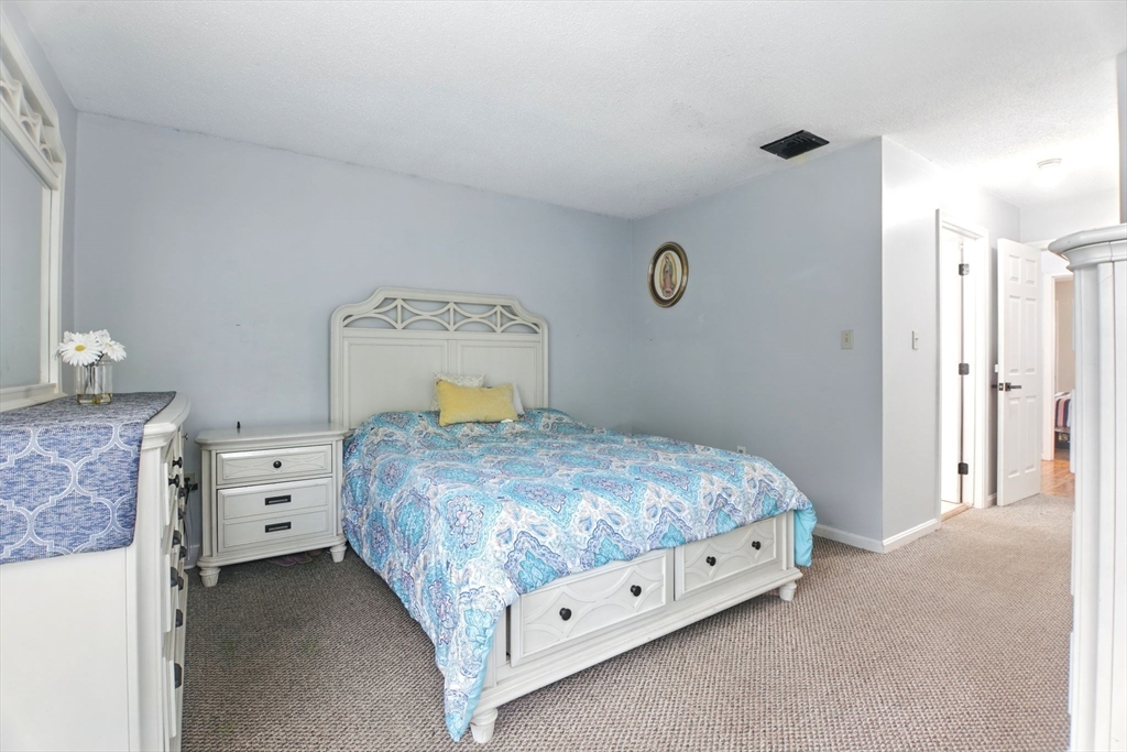 59 Castlegate Drive, Unit B Springfield, MA 01129 - Photo 26 of 42 a bedroom with a bed and a chandelier