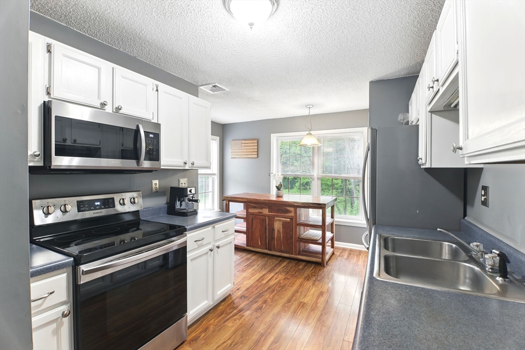 59 Castlegate Drive, Unit B Springfield, MA 01129 - Photo 4 of 42 a kitchen with a sink wooden floor and stainless steel appliances