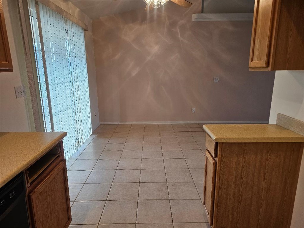 1069 Teddy Roosevelt Road Golden Valley, AZ 86413 - Photo 8 of 24 Kitchen with light countertops, brown cabinets, light tile patterned floors, and black dishwasher