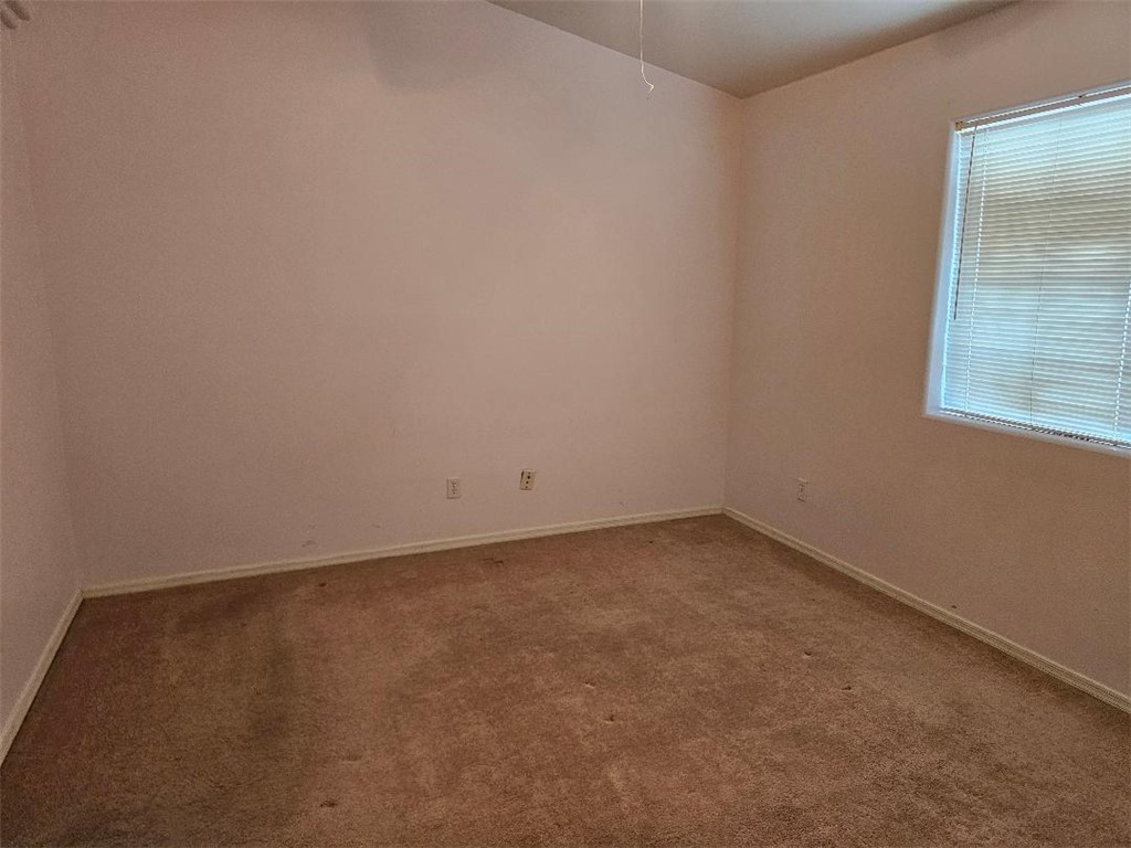 1069 Teddy Roosevelt Road Golden Valley, AZ 86413 - Photo 9 of 24 Empty room featuring dark colored carpet and baseboards
