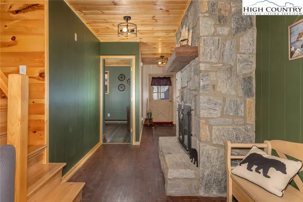 a view of a hallway with wooden floor and a living room