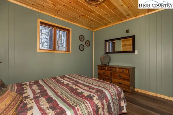 a bedroom with a bed and a lamp on dresser