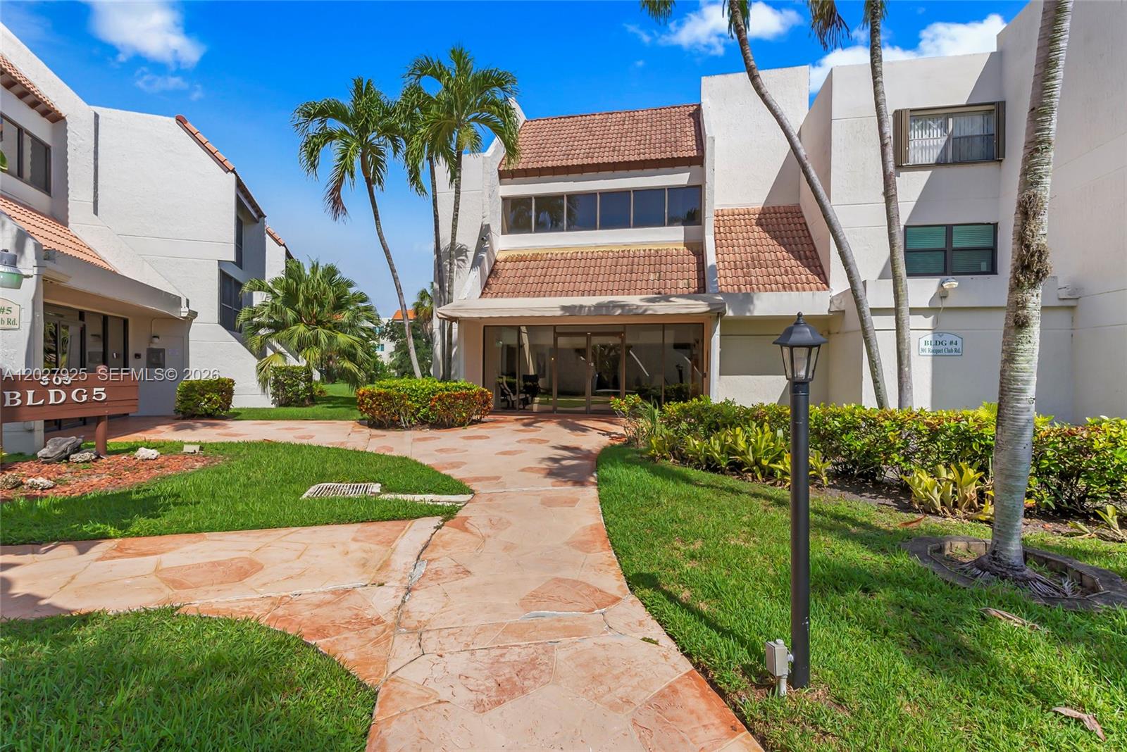 301 Racquet Club Road, Unit 103 Weston, FL 33326 - Photo 1 of 20 a front view of a house with a garden and plants