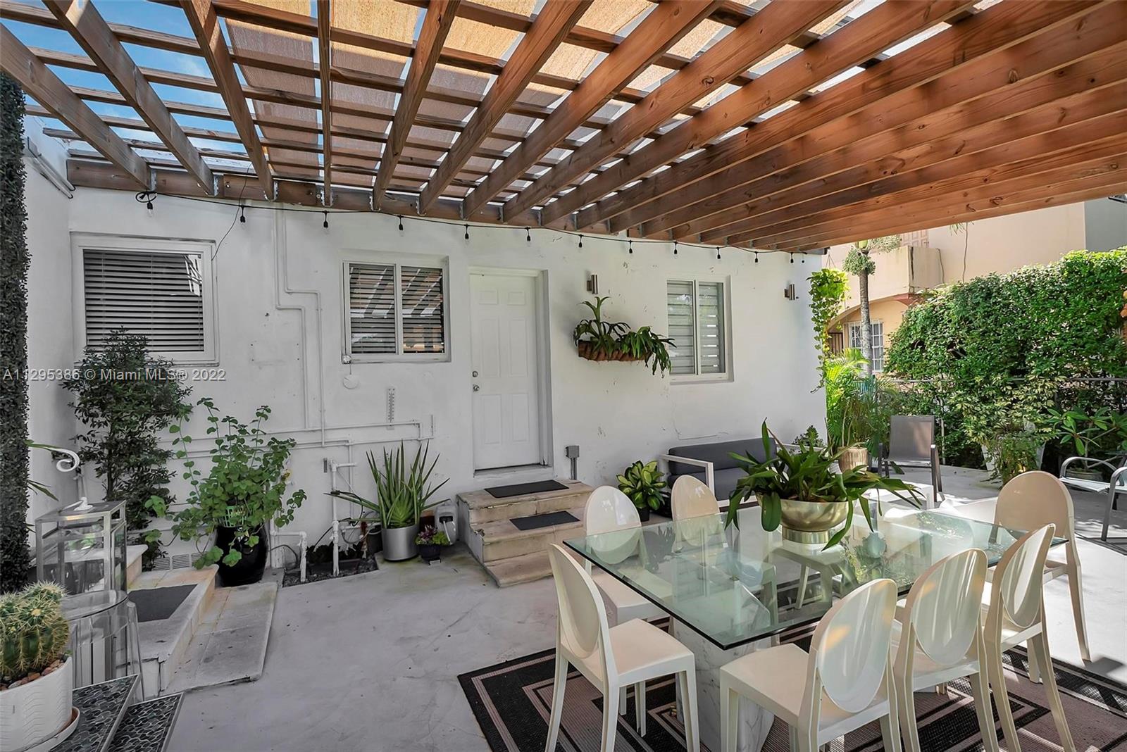 1242 Southwest 13th Avenue Miami, FL 33135 - Photo 14 of 42 a view of a patio with table and chairs potted plants with wooden floor