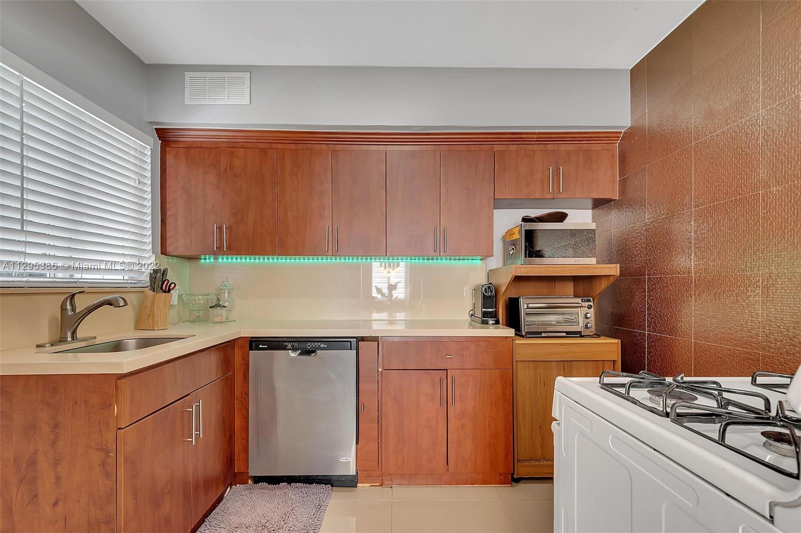1242 Southwest 13th Avenue Miami, FL 33135 - Photo 20 of 42 a kitchen with stainless steel appliances a sink stove and cabinets