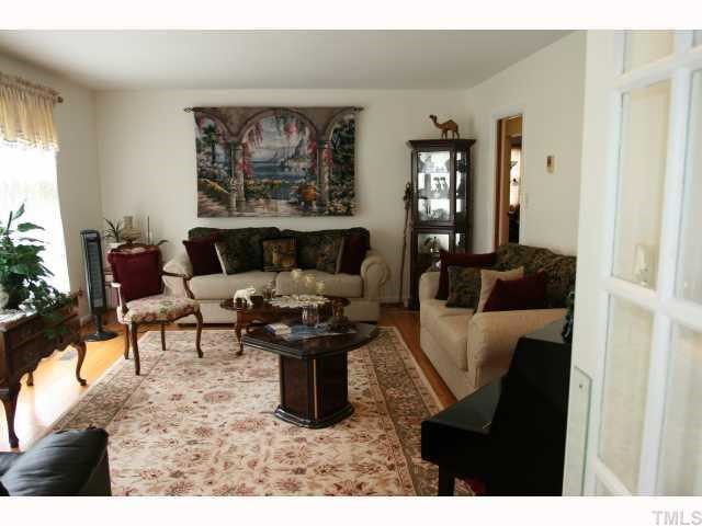 408 Roxanne Drive Raleigh, NC 27603 - Photo 3 of 7 a living room with furniture a window and a painting on the wall