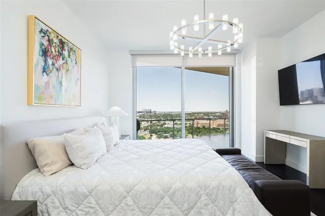 a spacious bedroom with a large bed and a chandelier