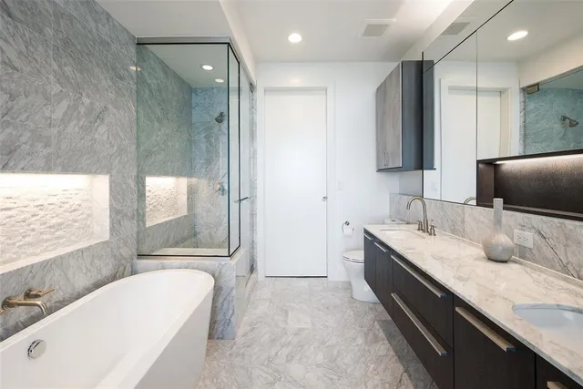 a bathroom with a granite countertop tub sink and mirror