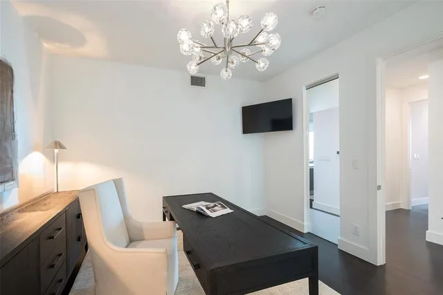 a living room with furniture a chandelier and a flat screen tv
