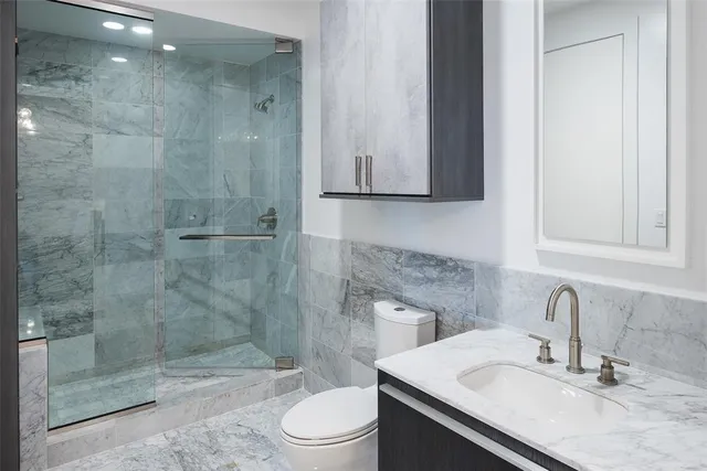 a bathroom with a sink a toilet and shower