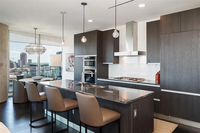 a kitchen with granite countertop a sink a counter and chairs