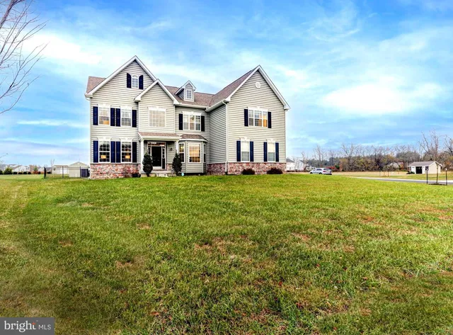 a view of a house with a big yard and large trees