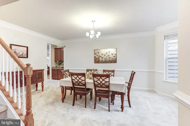 a bedroom with a bed a dresser and chandelier