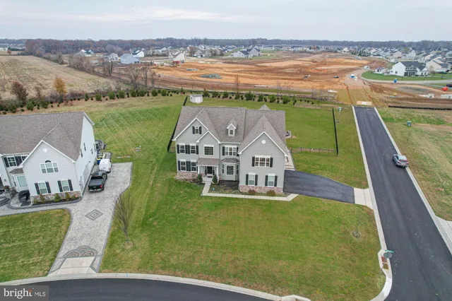 a view of a house with a big yard and large trees
