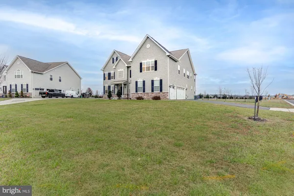 a kitchen with stainless steel appliances kitchen island granite countertop a table chairs and a refrigerator
