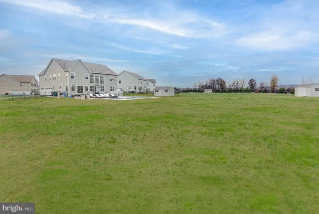 a kitchen with stainless steel appliances kitchen island granite countertop a table chairs and a refrigerator