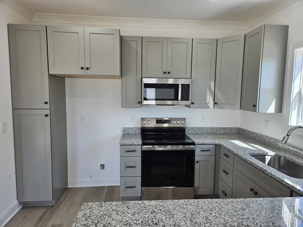 a kitchen with stainless steel appliances granite countertop a stove a sink and a refrigerator