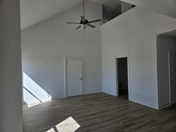 a view of a room with wooden floor and white walls
