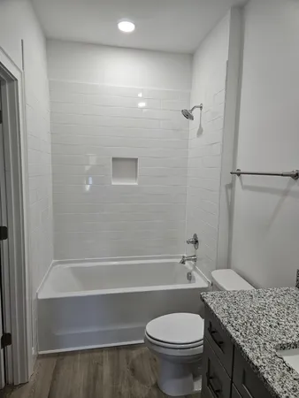 a bathroom with a granite countertop toilet sink and shower