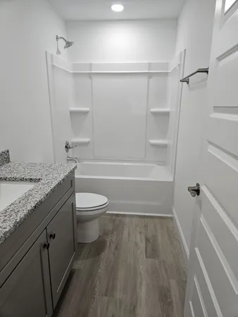 a bathroom with a granite countertop sink toilet and shower