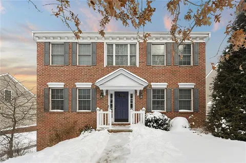 front view of a brick house with a yard