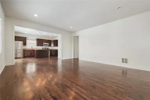 a view of a kitchen with wooden floor and a window