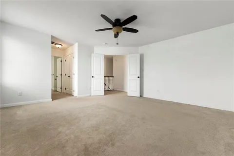 an empty room with closet and ceiling fan
