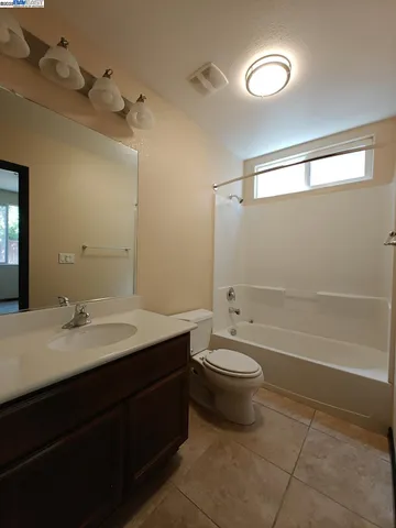 a bathroom with a granite countertop sink a toilet a mirror and shower