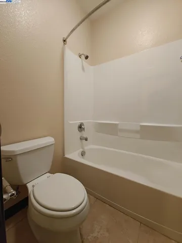 a bathroom with a toilet and a bath tub