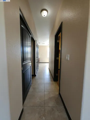 a view of a hallway with wooden cabinets