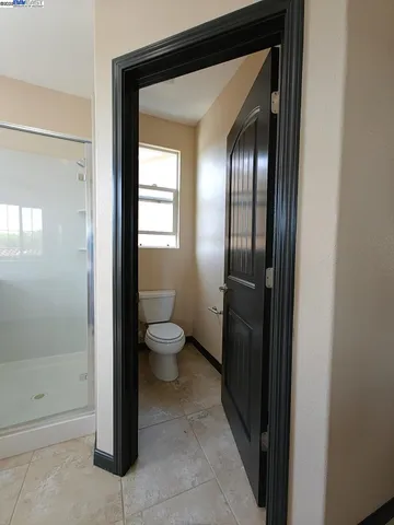 a bathroom with a toilet and a glass shower door