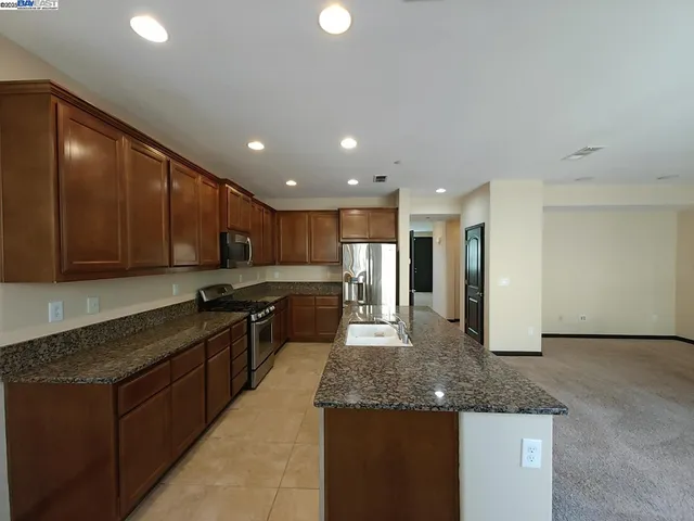 a kitchen with stainless steel appliances granite countertop a sink stove and cabinets